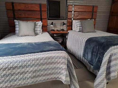 two beds sitting next to each other in a bedroom at Rustic Farm Stay in Lydenburg
