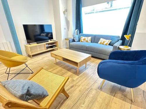 un salon avec un canapé bleu et une télévision dans l'établissement BASTiLLE SUNbEAM - Luxury flat 80m2 - Paris 6p 2BR, à Paris