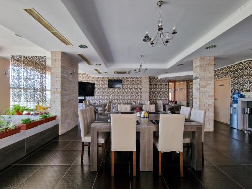 a dining room with a table and white chairs at Айляк Клуб Хисаря - Бутиков Хотел&СПА с Elegant Ultra All Inclusive in Hisarya