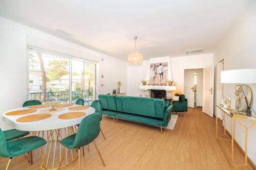 un salon avec un canapé vert et une table dans l'établissement La Villa les Pins, à Saint-Georges-de-Didonne