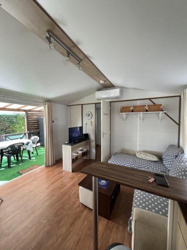 une pièce avec un lit et une table dedans dans l'établissement Camping Del Mar 42, Mobile Home O'Hara, 2 chambres, 4 personnes, bord de mer, à Argelès-sur-Mer