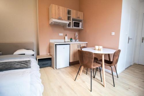 a small room with a table and a small kitchen at Studios Saint Jacques, Châtellerault in Châtellerault