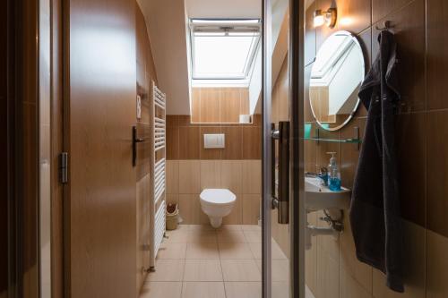 a bathroom with a toilet and a sink and a window at Ubytovanie Eva in Oščadnica