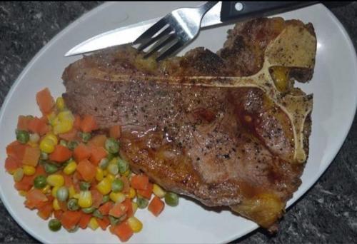 a plate of meat and vegetables with a fork at Chilly Beach Resort Palawan in Aborlan