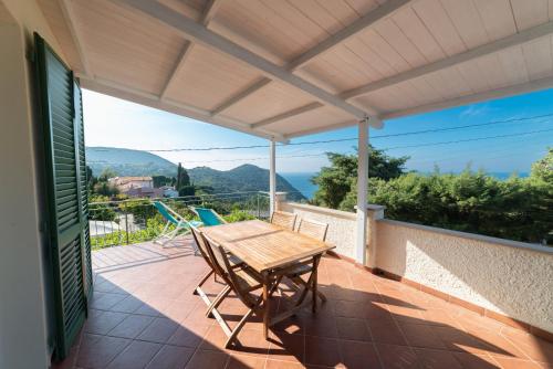 a patio with a wooden table and chairs on a balcony at Il Cisto in Marciana