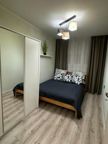 a bedroom with a bed and a large mirror at Apartament Niedurnego 38 in Ruda Śląska