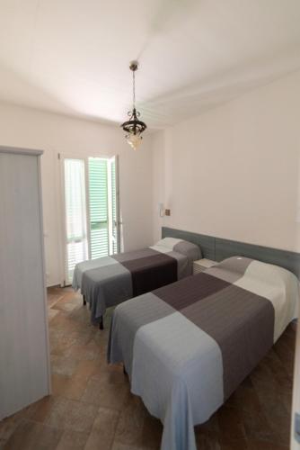 a room with four beds and a chandelier at Il Cisto in Marciana