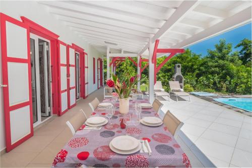 a dining table on the patio of a house at Residence Les Essences de Menard in Saint-Louis