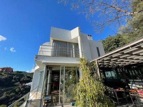a white house with glass doors and a balcony at Marbella Boutique Art suites in Marbella