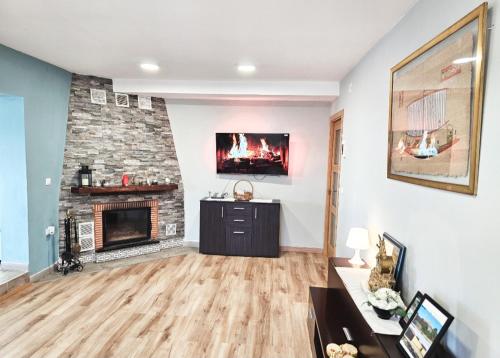 a living room with a fireplace and a couch at Casa El Mirador in Trijueque