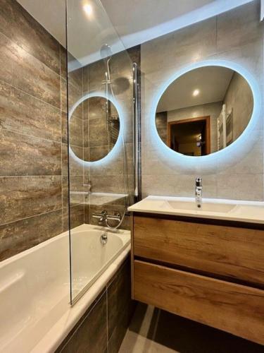 une salle de bain avec une baignoire, un lavabo et un miroir dans l'établissement Résidence Rond-point Des Pistes Iii - Appartement 2 pièces pour 4 personnes situé à Val d’Isère, skis aux pieds et à 500m du centre du village, navettes gratuites au MAE-1798, à Val dʼIsère
