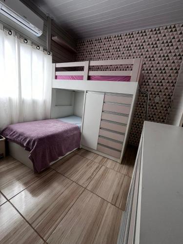 a small room with a bunk bed in a room at Casa a 1 km andando até a praia, barra sul de Balneário Camboriú in Balneário Camboriú