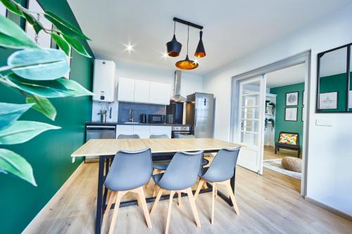 une cuisine et une salle à manger avec une table en bois et des chaises bleues dans l'établissement BE-1 - Appartement F4 pour 1-6 pers 1er étage au centre de Mulhouse, à Mulhouse