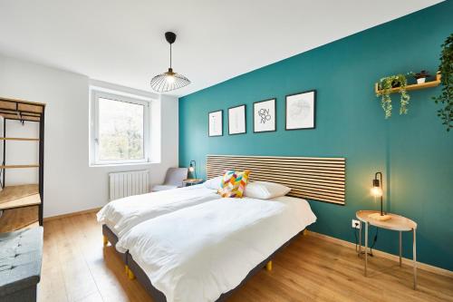 une chambre avec un grand lit et un mur bleu dans l'établissement BE-1 - Appartement F4 pour 1-6 pers 1er étage au centre de Mulhouse, à Mulhouse