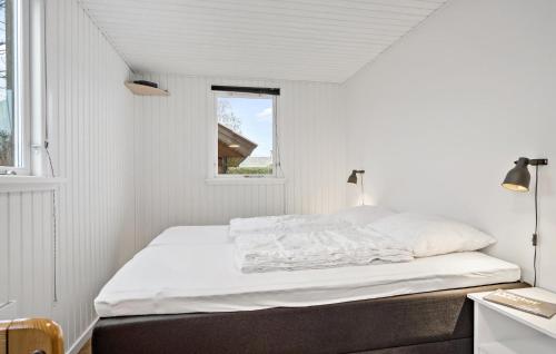a white bedroom with a bed and a window at Four-Bedroom Holiday Home In Middelfart in Middelfart