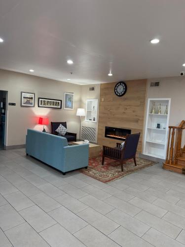a living room with a couch and a clock on the wall at Country Inn & Suites by Radisson, Elgin, IL in Elgin