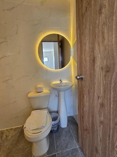 a bathroom with a toilet and a sink and a mirror at Amoblados la 19 in Ríohacha