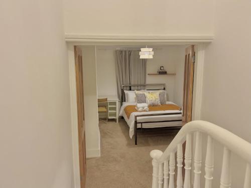 a bedroom with a bed and a stairway at Spacious 3 bedroom house near Central London, O2, ExCel, Abba Voyage, Stratford, Tube Station & Parking Available in London