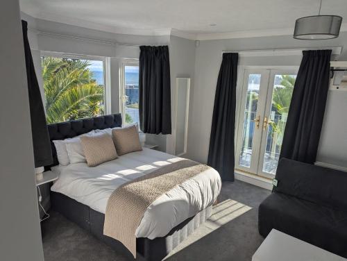 ルーにあるFieldhead Hotel, Looeのベッドと大きな窓のある寝室