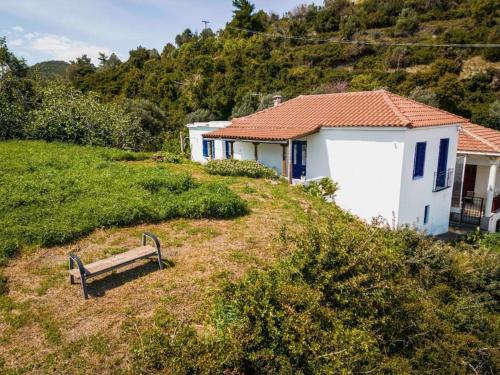 a bench sitting on a hill next to a house at Traditional house near the sea in Platána