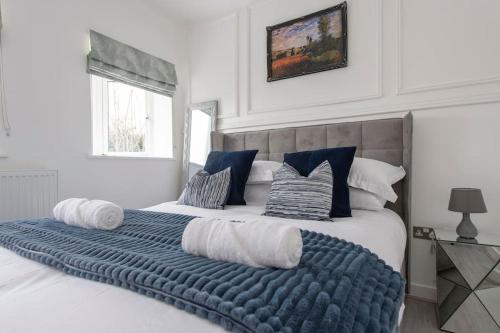 a bedroom with a large bed with a blue blanket at Elegant & Spacious 1 Bed Flat, Crayford, Dartford in Slades Green