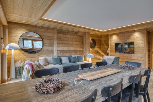 un salon avec une table et un canapé dans l'établissement Chalet Prestige Hélios 12 guests, à Megève