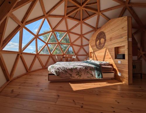 - une chambre avec un lit dans une pièce dotée d'une grande fenêtre dans l'établissement Le dôme du Roc, à Belloc