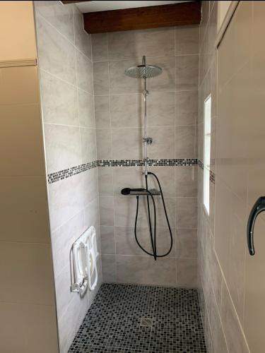 La salle de bains est pourvue d'une douche et de carrelage noir. dans l'établissement Maison familiale avec piscine proche Périgueux, à Chancelade