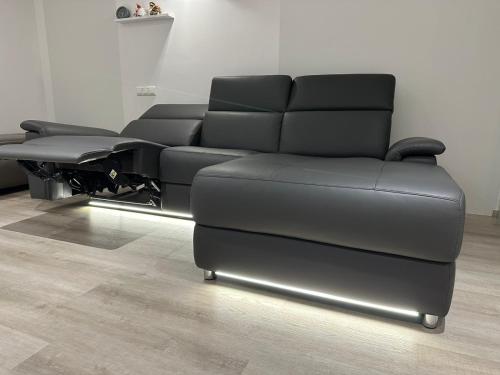 a black couch sitting in a living room at FerienWohnung Gästehaus Merzig-Besseringen NEUBAU in Merzig