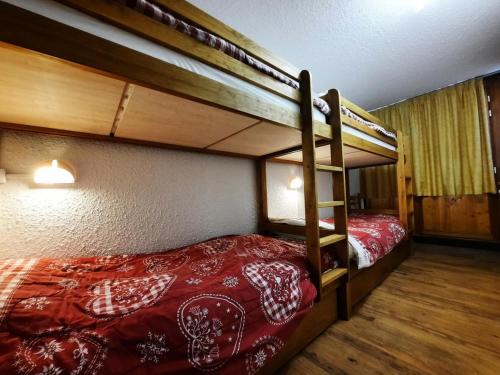 - une chambre avec 2 lits superposés et des draps rouges dans l'établissement Résidence Pelvoux - Appartement pour 8 au coeur des Ménuires et ski aux pieds MAE-4394, aux Menuires