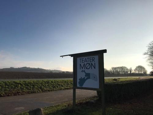 a sign in front of a field next to a road at Stort smukt hus med havudsigt tæt på Møns Klint in Borre