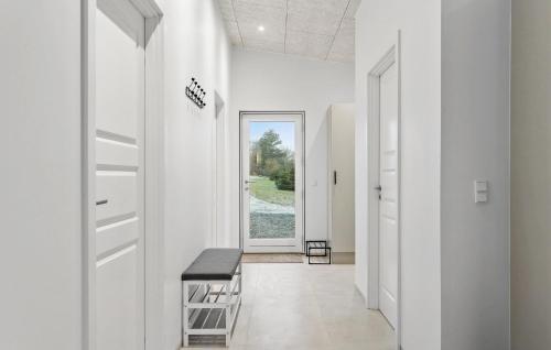 a hallway with white walls and a door with a bench at Gorgeous Home In Rudkøbing With Wifi in Spodsbjerg
