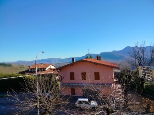 a pink house with a truck parked in front of it at Hotel Veles in Querciola