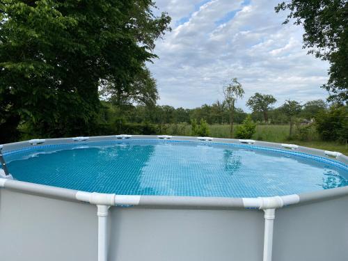 une grande piscine sur une clôture blanche dans l'établissement Gite la Pomme de Pin bij boerderij, à Sazeray