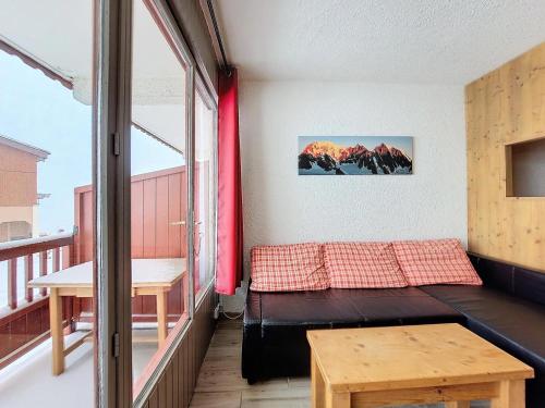 Cette chambre dispose d'un balcon avec un lit et une table. dans l'établissement Les Chalets De La RosiÈre - Studio de 25m² pour 4 personnes MAE-8004, à Montvalezan