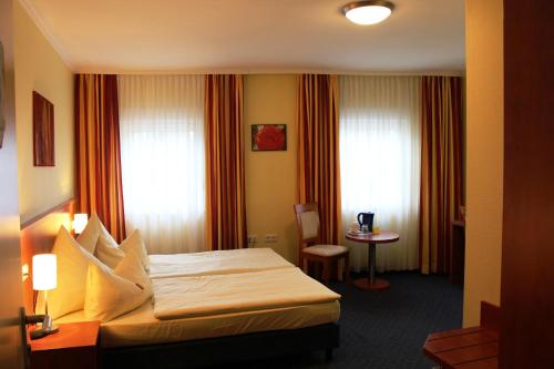 pokój hotelowy z łóżkiem i stołem w obiekcie Parkhotel Rüdesheim w mieście Rüdesheim am Rhein