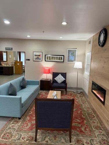 a living room with a blue couch and a fireplace at Country Inn & Suites by Radisson, Elgin, IL in Elgin