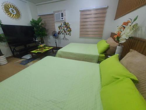 a living room with two beds and a flat screen tv at Staycation ni Inday in Trece Martires
