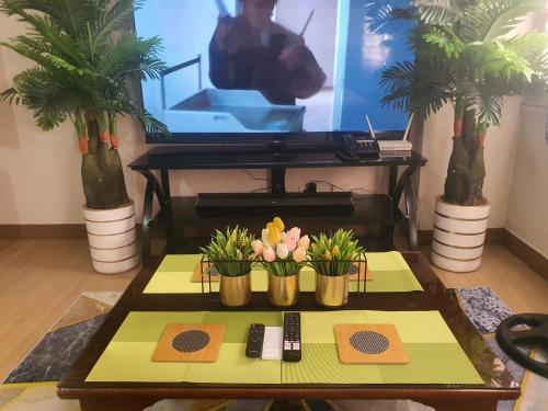a living room with a table with flowers and a tv at Staycation ni Inday in Trece Martires