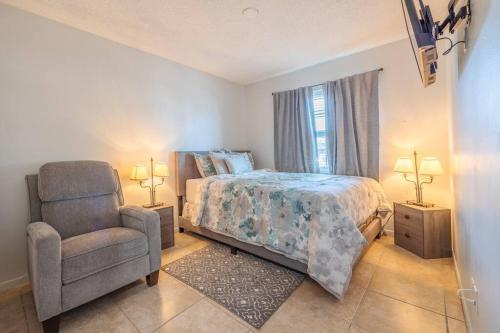 a bedroom with a bed and a chair at Peaceful in Royal Palm Beach