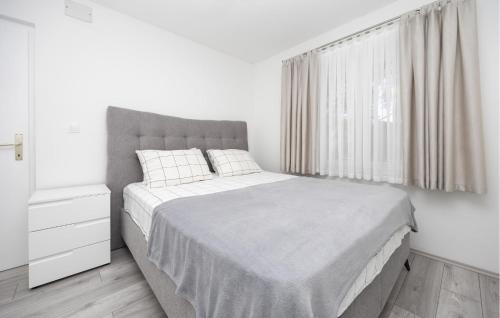 a white bedroom with a large bed and a window at Amazing Apartment In Imotski in Imotski