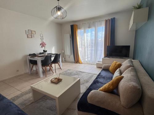 un salon avec un canapé et une table dans l'établissement Appartement lumineux Parking proche transport, au Bourget