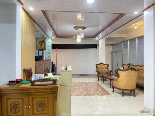 a room with chairs and a desk in a room at New Wijaya Hotel in Yogyakarta