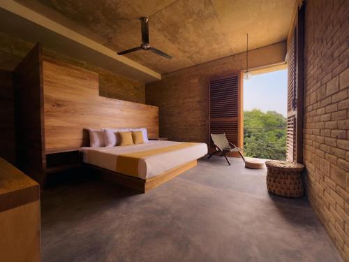 a bedroom with a bed and a brick wall at Torrearena Design Hotel in Puerto Escondido