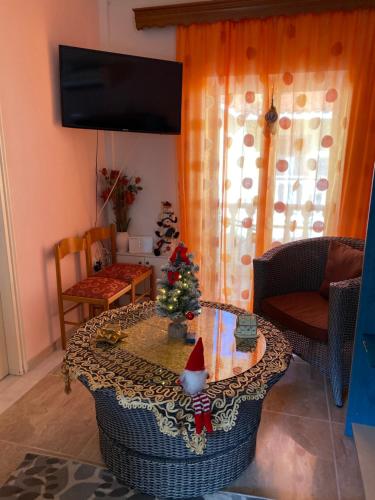 a living room with a table with a christmas tree on it at Helen's Seaside Apartment in Nafpaktos