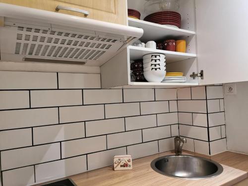 une cuisine avec un évier et du carrelage blanc du métro dans l'établissement Sefcotel - Studio Cabine COSY MAE-3024, à Tignes