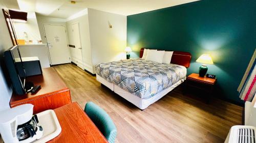 a bedroom with a bed and a green wall at Studio 6 Suites Portland, OR Downtown OHSU in Portland