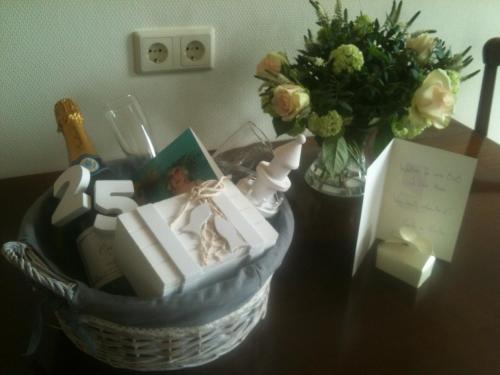 una cesta de regalos en una mesa con un jarrón de flores en De Oude Haven, en Zierikzee