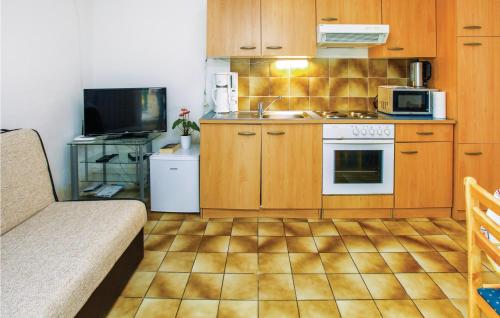 a kitchen with wooden cabinets and a stove top oven at 1 Bedroom Beautiful Apartment In Lucija in Lucija