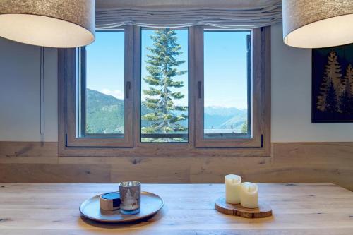 a dining room with a table with candles and windows at Tanau-Rentals El Oso in Naut Aran